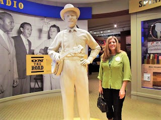 Sally Matheny standing beside a statue of Earl Scruggs