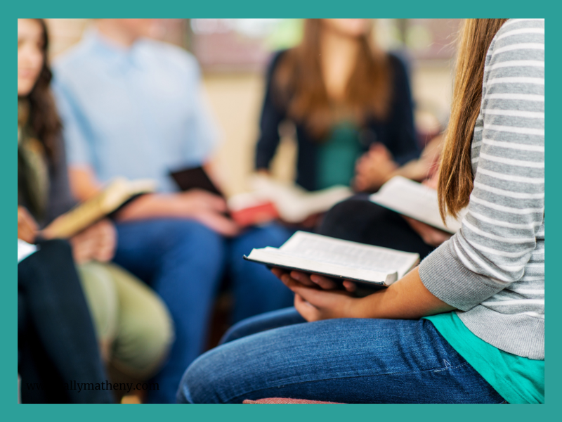 Group of teens holding Bibles and talking together.