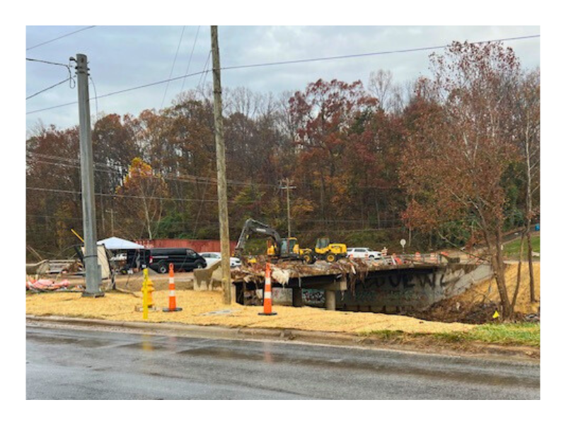 Shows two bulldozers and workers working on a bridge after Hurricane Helene.